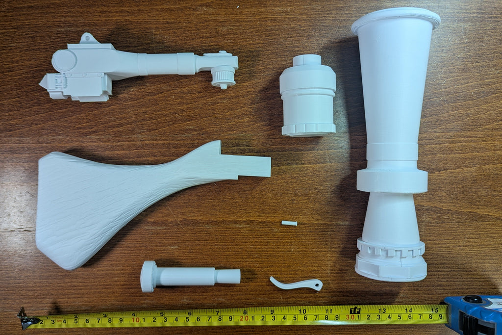 White unpainted Jawa Ion Blaster DIY kit parts laid out beside a tape measure