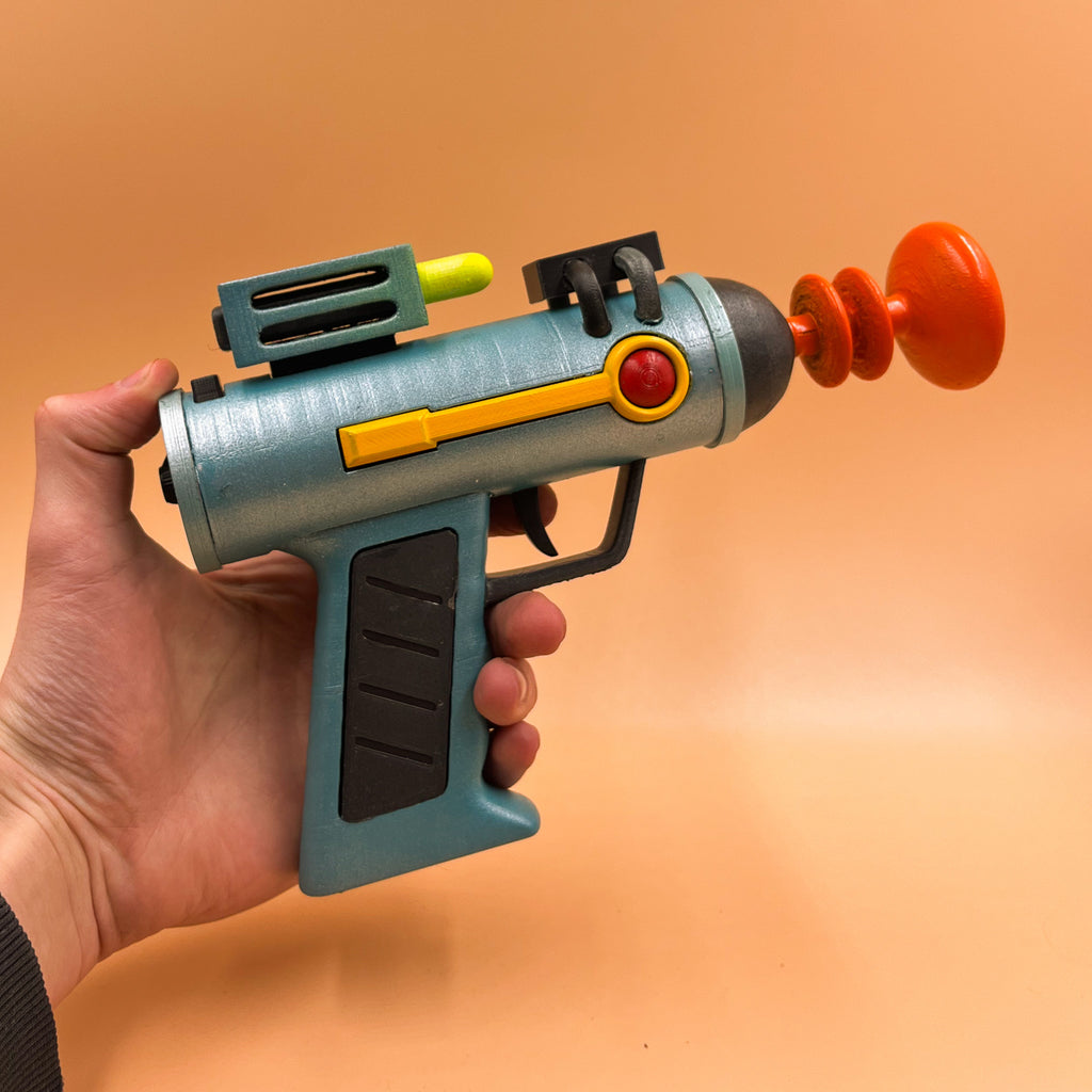 Finished 3D printed Rick Sanchez laser gun cosplay prop held against an orange background